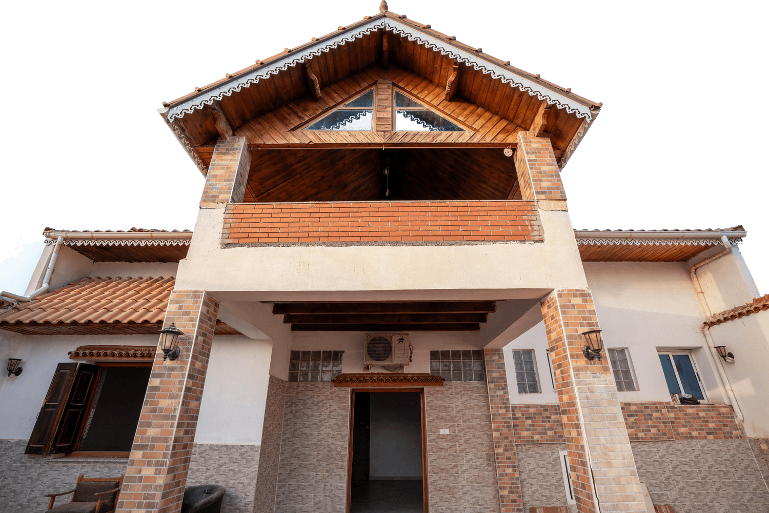 Une villa traditionnelle au pignon en bois et aux colonnes de brique
